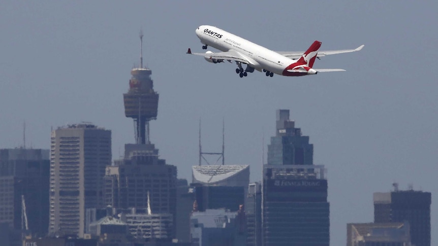 A jet takes off with the Sydney CBD in the background