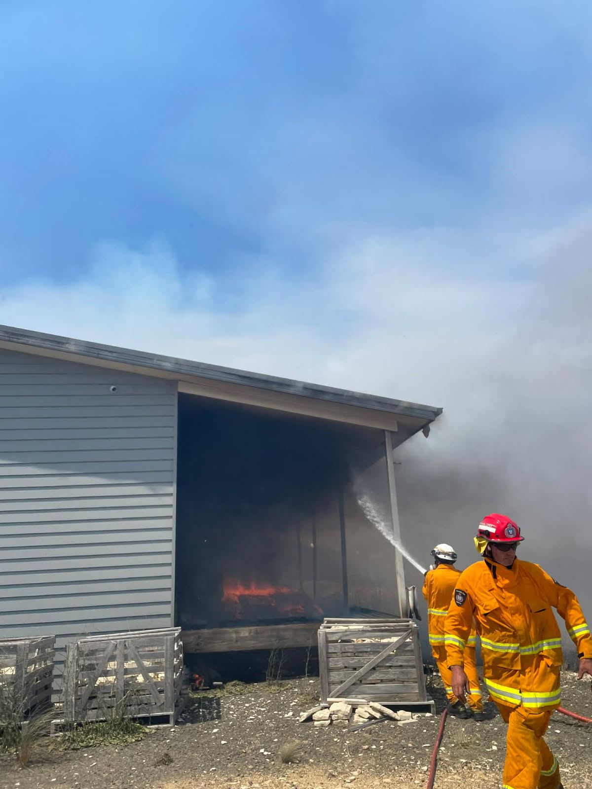 Un bombero apaga una cabaña en llamas.