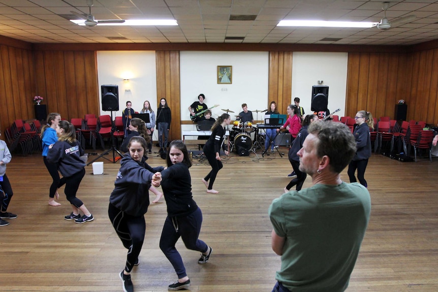 Man watching kids rehearse a play