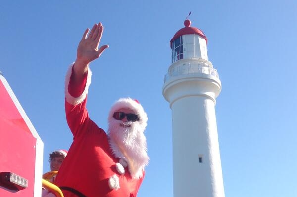 Santa on a fire truck in front of the Aireys Inlet lighthouse