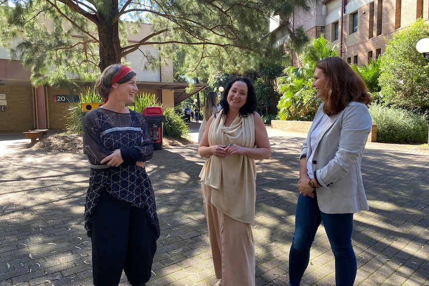 Three women standing outside