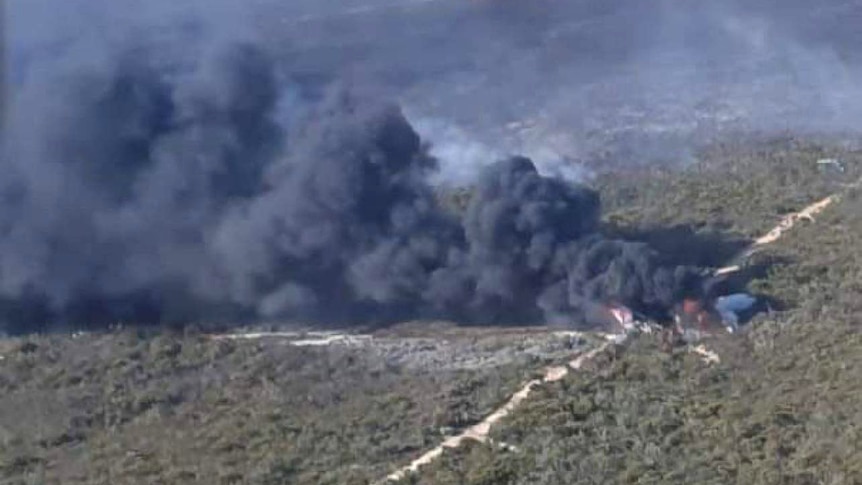 A smoke plume coming out of bushland in an aerial shot. 