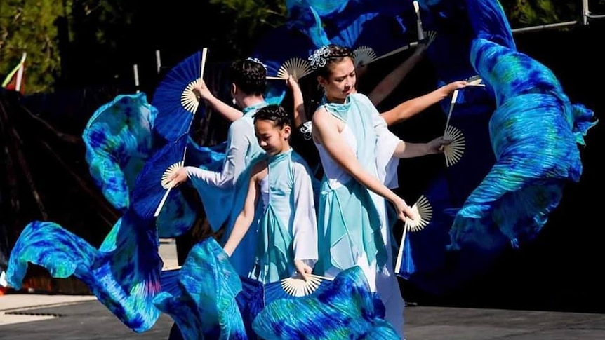 Chinese dancers with bright blue fans.