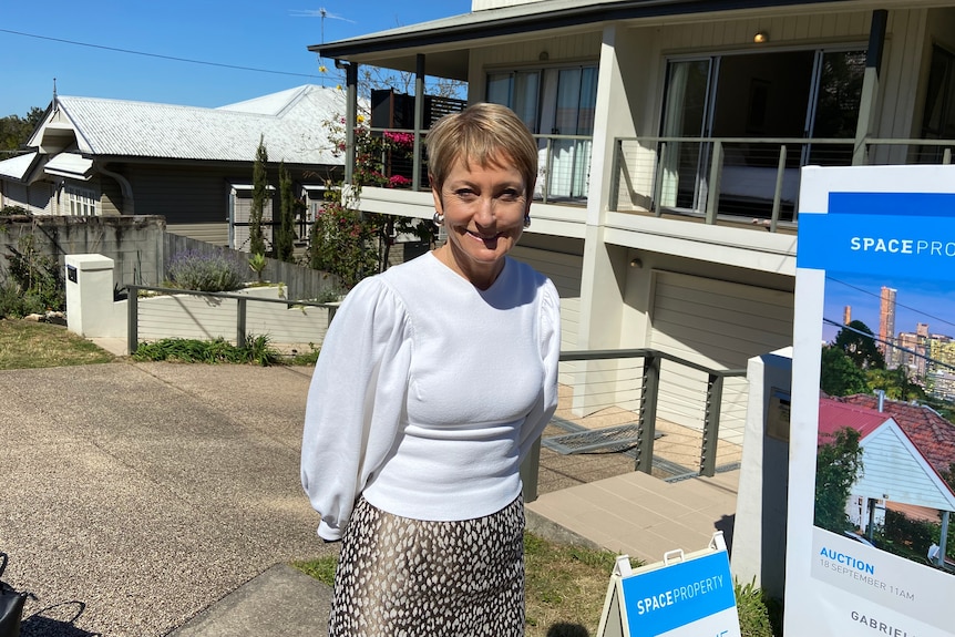 A smiling woman stands in front of a unit.