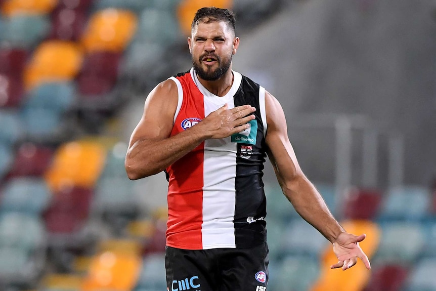 A St Kilda AFl player puts his right hand on the left side of his chest in an elimination final against Western Bulldogs.