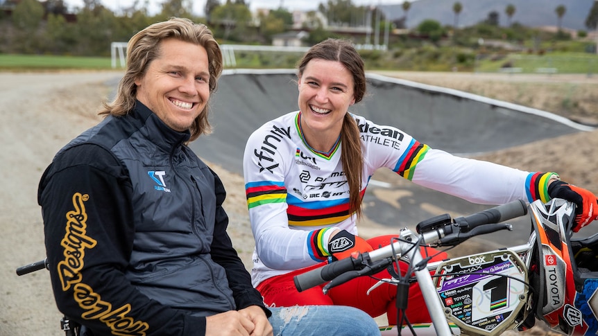 Sam and Alise Willoughby pose and smile together at a BMX track.