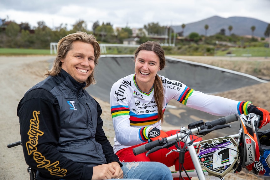 Sam and Alise Willoughby pose and smile together at a BMX track.