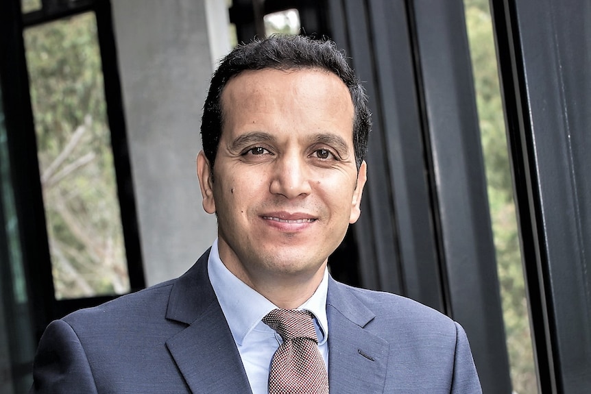 A man in suit smiles at camera