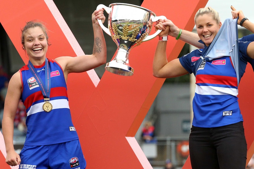Ellie Blackburn and Katie Brennan hold the AFLW premiership trophy.
