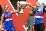 Ellie Blackburn and Katie Brennan hold aloft the AFLW premiership trophy.
