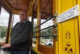 A man stands behind the wheel of a tram