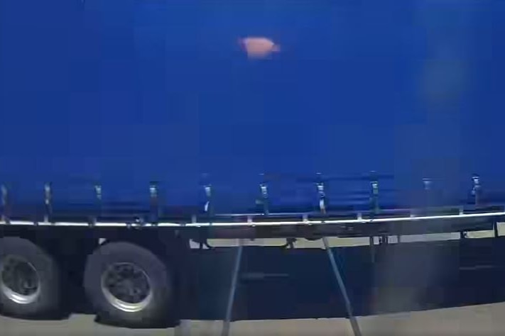 A close up of a blue truck passing. 