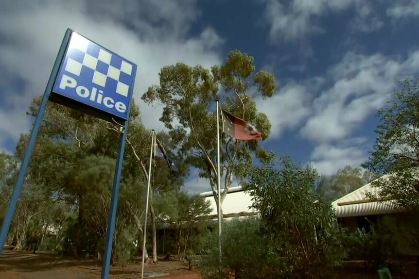 A still image taken from ABC News footage of the Yulara Police Station, which is seen behind gum trees.