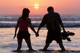 A couple watches the sun set at Kuta Beach on Bali. (Reuters)