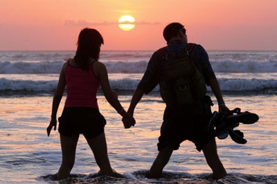 A couple watches the sun set at Kuta Beach on Bali.