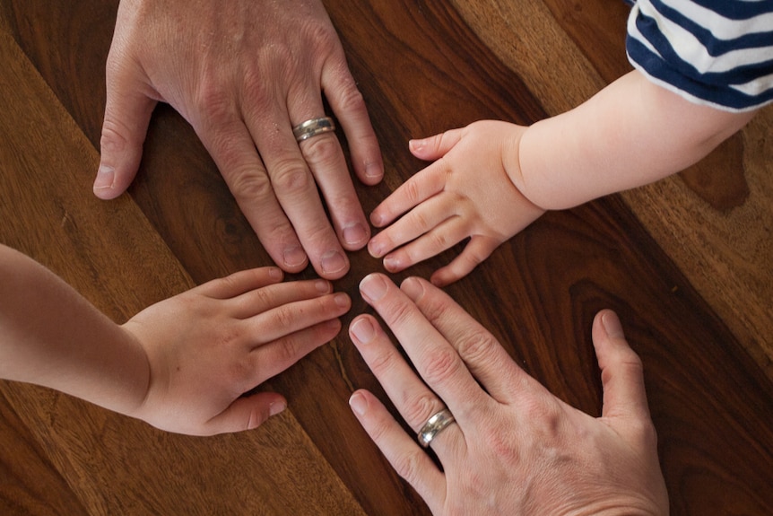 The hands of Dylan, Blue, Joshua and Shaun on a table.