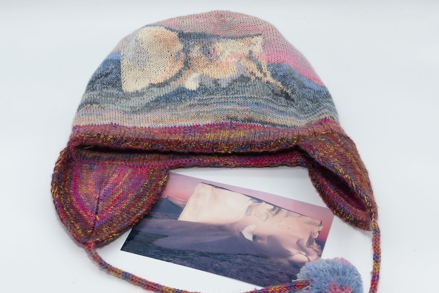 A pink and blue knitted beanie depicting a picture of an iceberg.