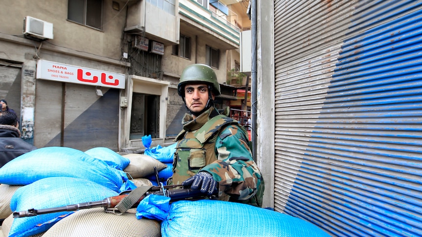 A Syrian soldier secures a checkpoint in Homs (file photo)