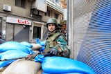 A Syrian soldier secures a checkpoint in Homs