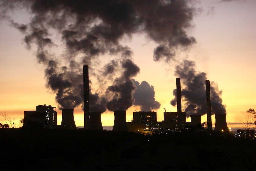 Smoke rises from Loy Yang Power Station, which is seen in silhouette against a yellow sunset