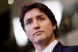 A close up of Justin Trudeau wearing a suit, with a serious expression on his face 