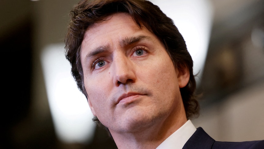 A close up of Justin Trudeau wearing a suit, with a serious expression on his face 