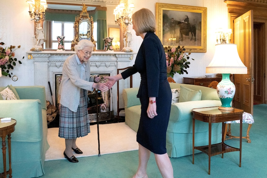 The Queen shaking hands with Liz Truss in a living room 