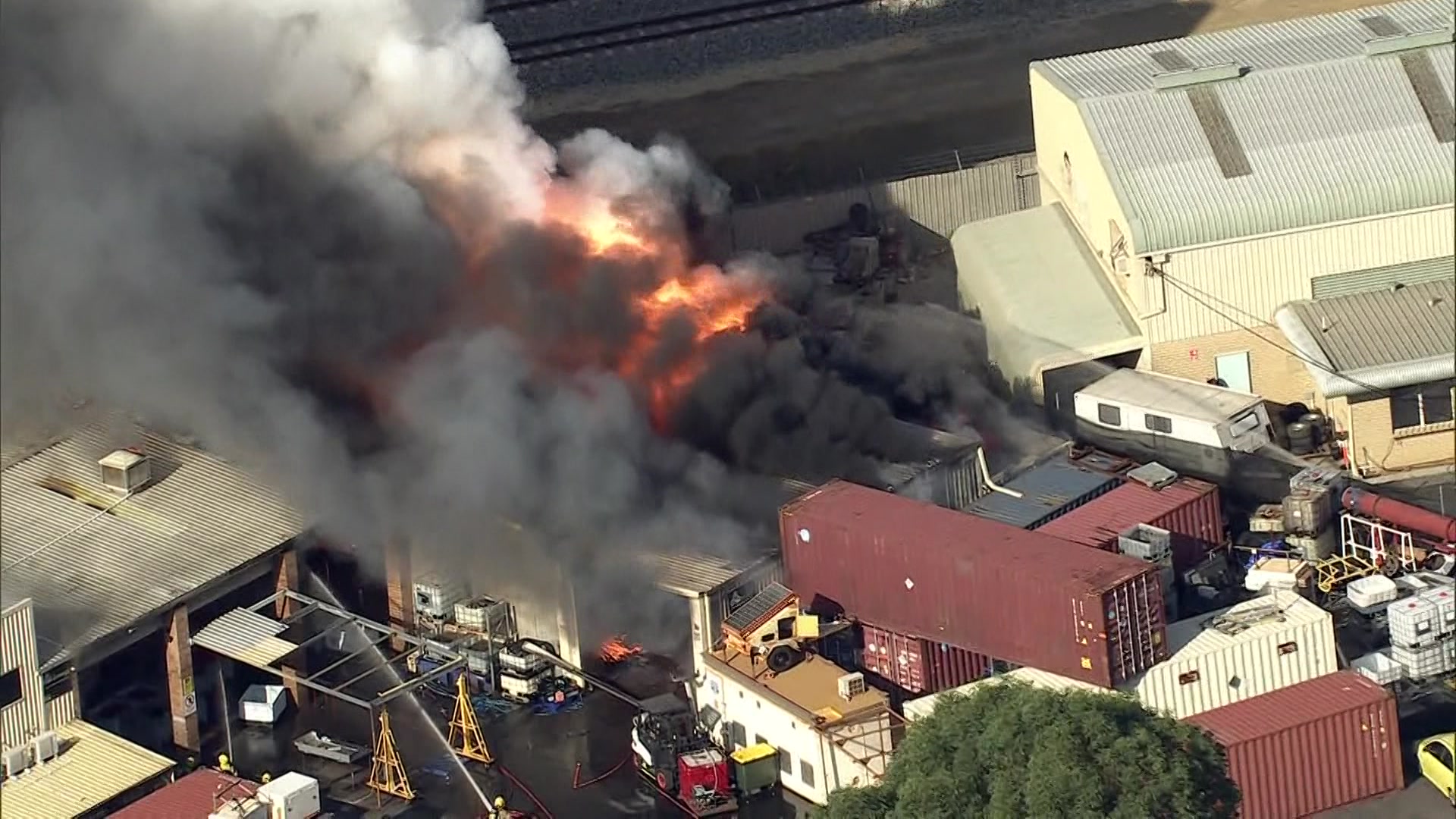 औद्योगिक क्षेत्र की एक इमारत से आग की लपटें निकलती देखी जा सकती हैं। 