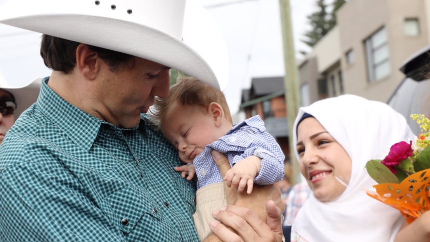 Canadian Prime Minister Justin Trudeau holding a baby named after him.