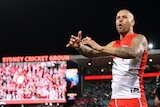 Sydney AFL star Lance Franklin calls out and holds his hands to the crowd in celebration after a finals win for Sydney Swans.