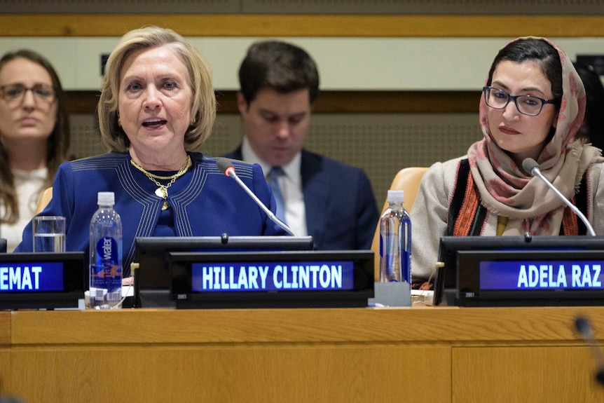 US Secretary of State Hillary Clinton speaks from behind a desk wearing a blue suit.