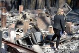 Catherine Hubbard stands in the burnt out ruins of her house