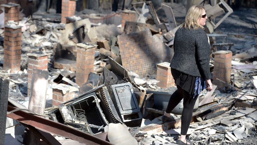 Catherine Hubbard stands in the burnt out ruins of her house