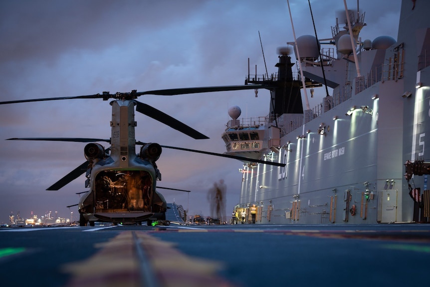 Helikopter na doku obok statku australijskiej marynarki wojennej HMAS Adelaide w Brisbane.
