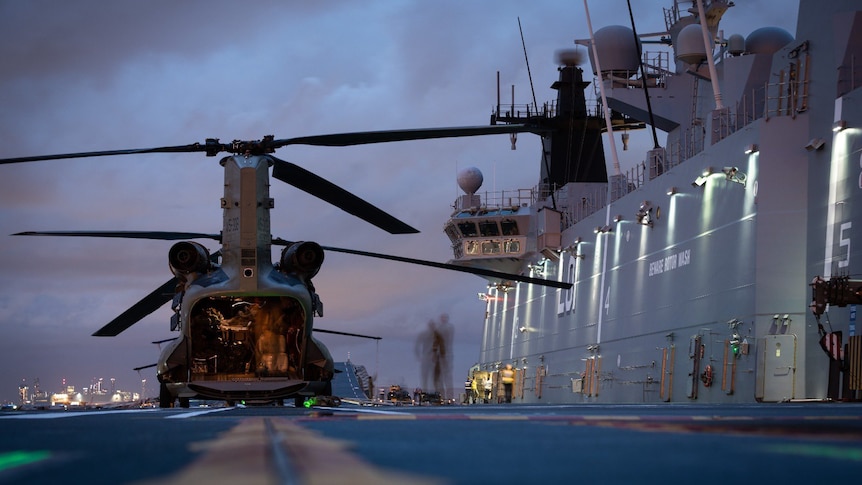 A helicopter on the dock beside Australian navy ship HMAS Adelaide, at Brisbane.