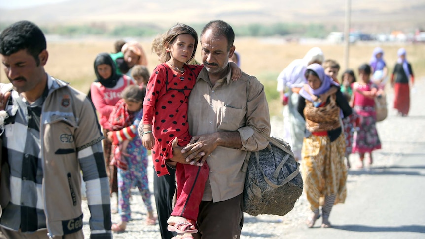 Man walks with Yazidi child