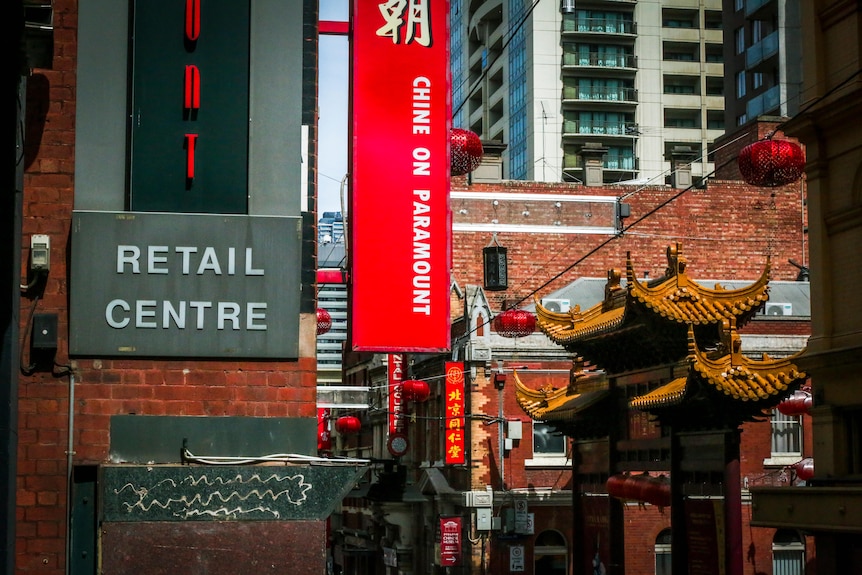 A photo of Melbourne's Chinatown showing the top of the archway and a "retail centre" sign.