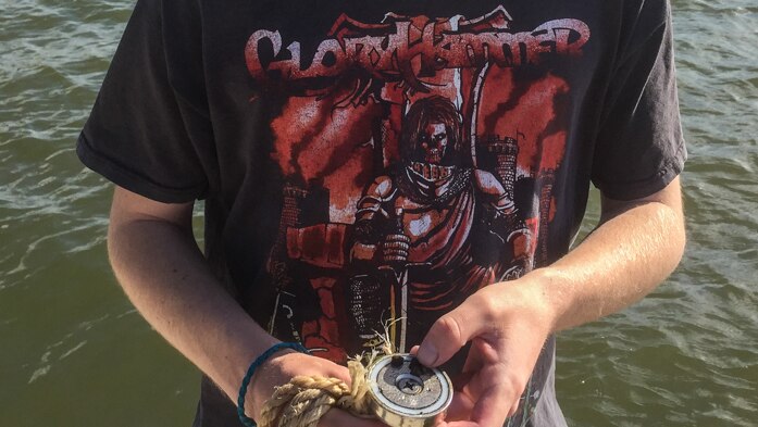 Young man holds a magnet attached to a rope.