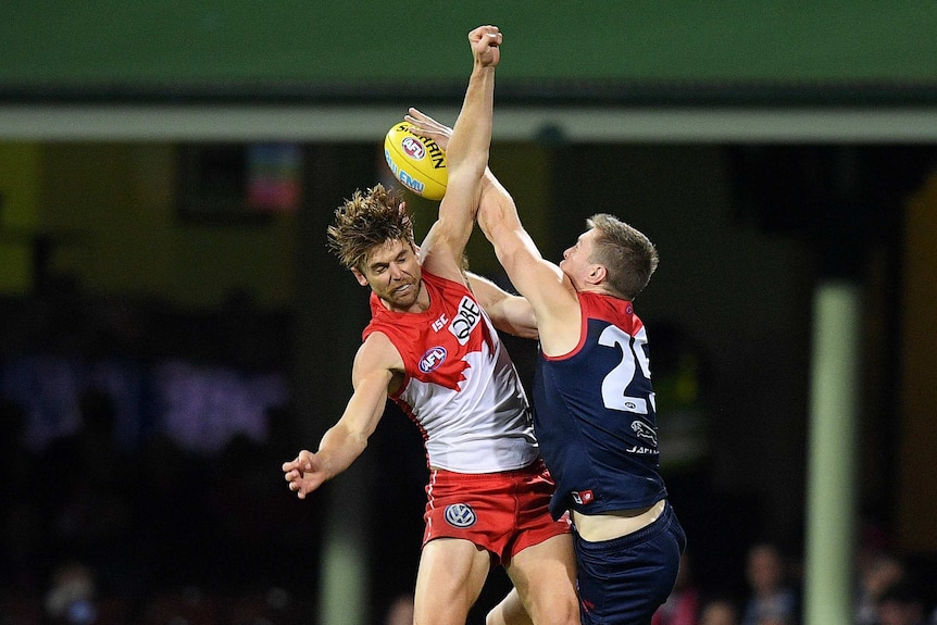 Dane Rampe and Tom McDonald both leap for the ball and jump into each other