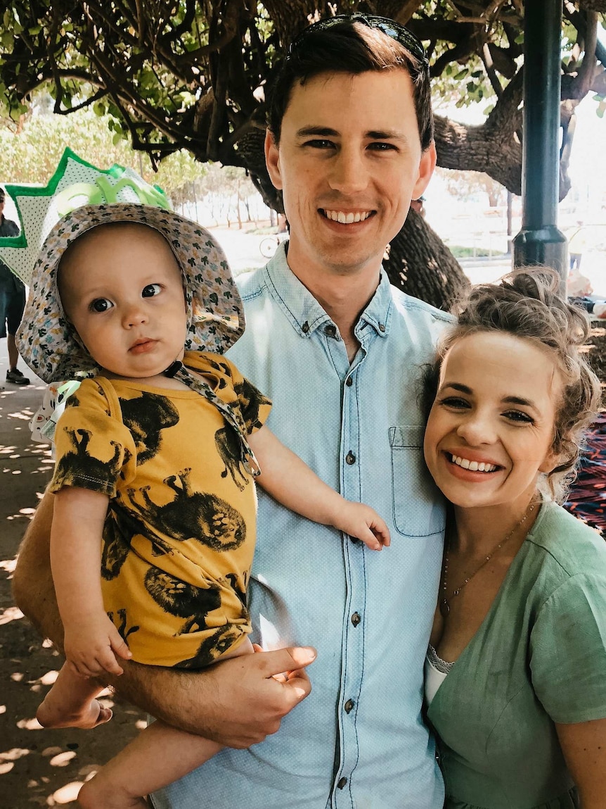 Kate Irwin stands next to her husband Tom who is holding their baby