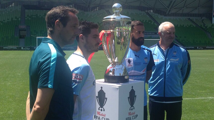 Melbourne City's (L) and Sydney FC's (R) coaches and captains with the FFA Cup on November 29, 2016.