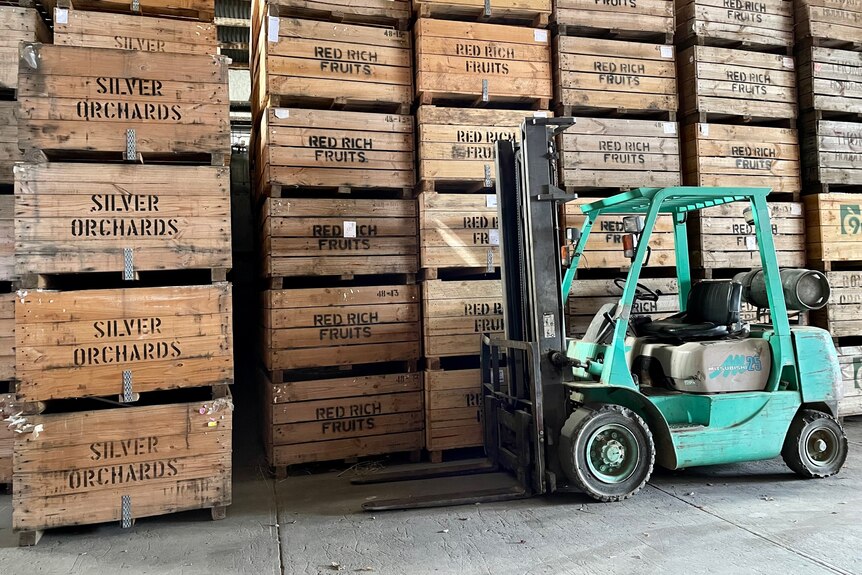 A stack of crates and a forklift.