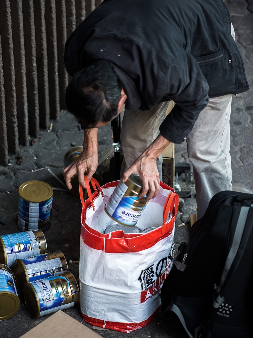 A man packs a bag with baby formula in China