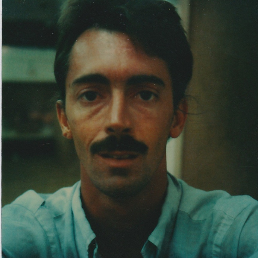 A young Ken Kasik, with black hair and a think moustache, looks at the camera.