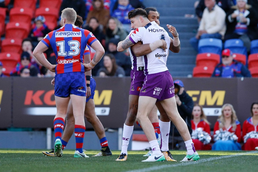 Curtis Scott is hugged by a teammate after scoring a try for the Storm.