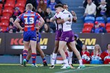 Curtis Scott is hugged by a teammate after scoring a try for the Storm.