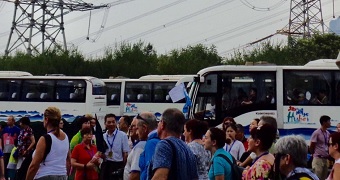 A convoy of busses with foreign tourists at a mandatory factory stop in China.