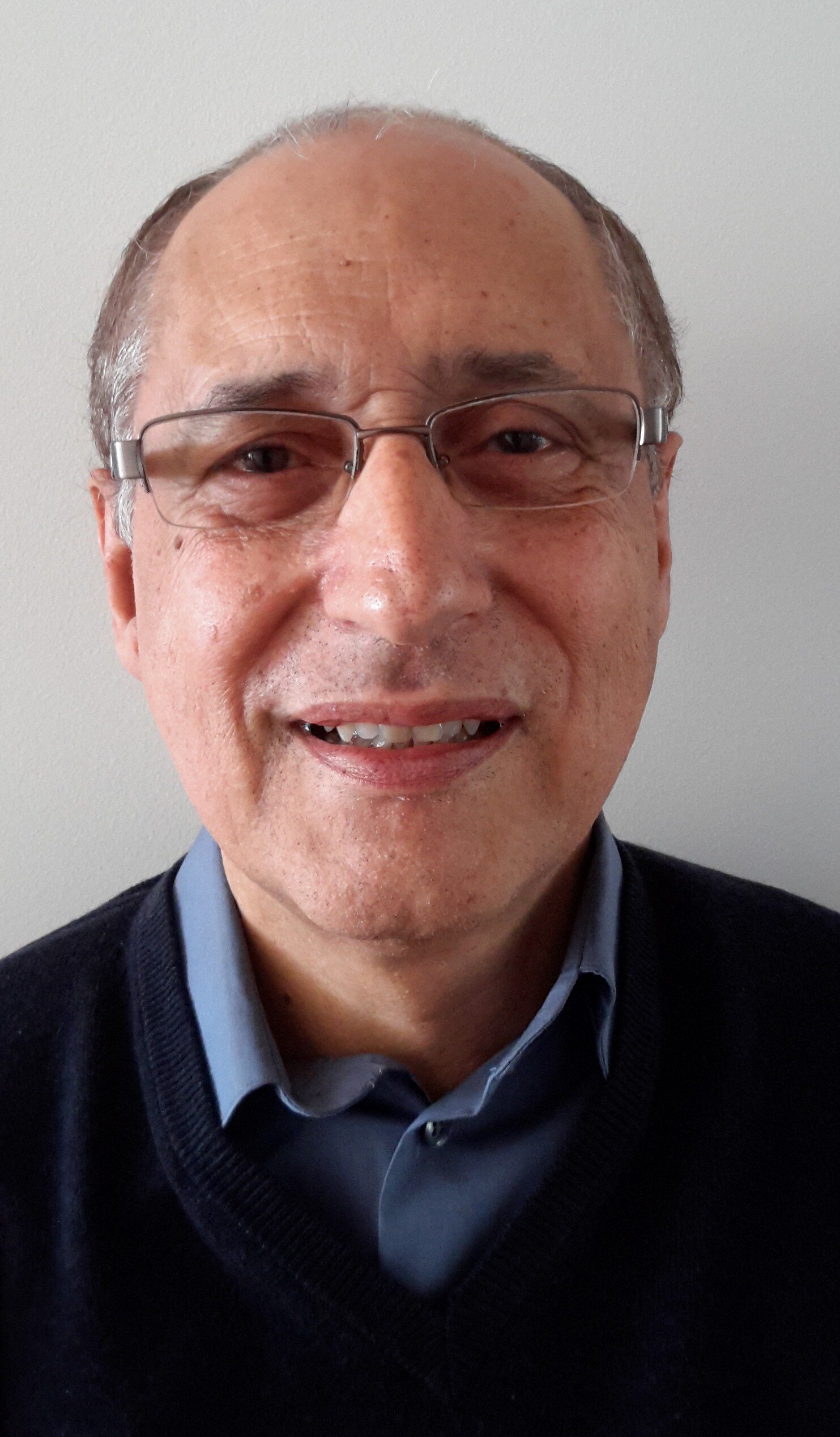 Man smiles with glasses at camera 