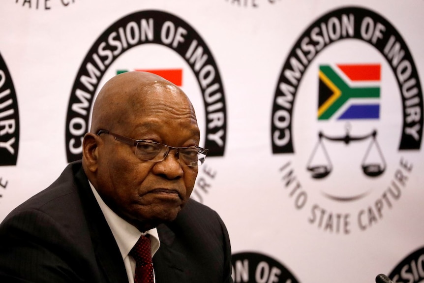 Jacob Zuma looks in the direction of the camera with an unhappy expression on his face.