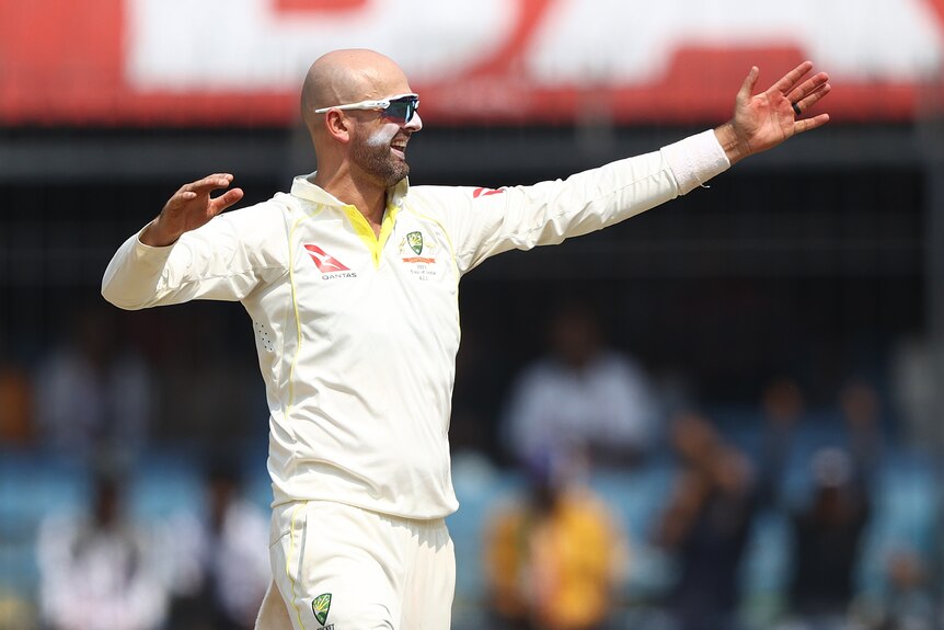 Nathan Lyon holds out his hand and smiles